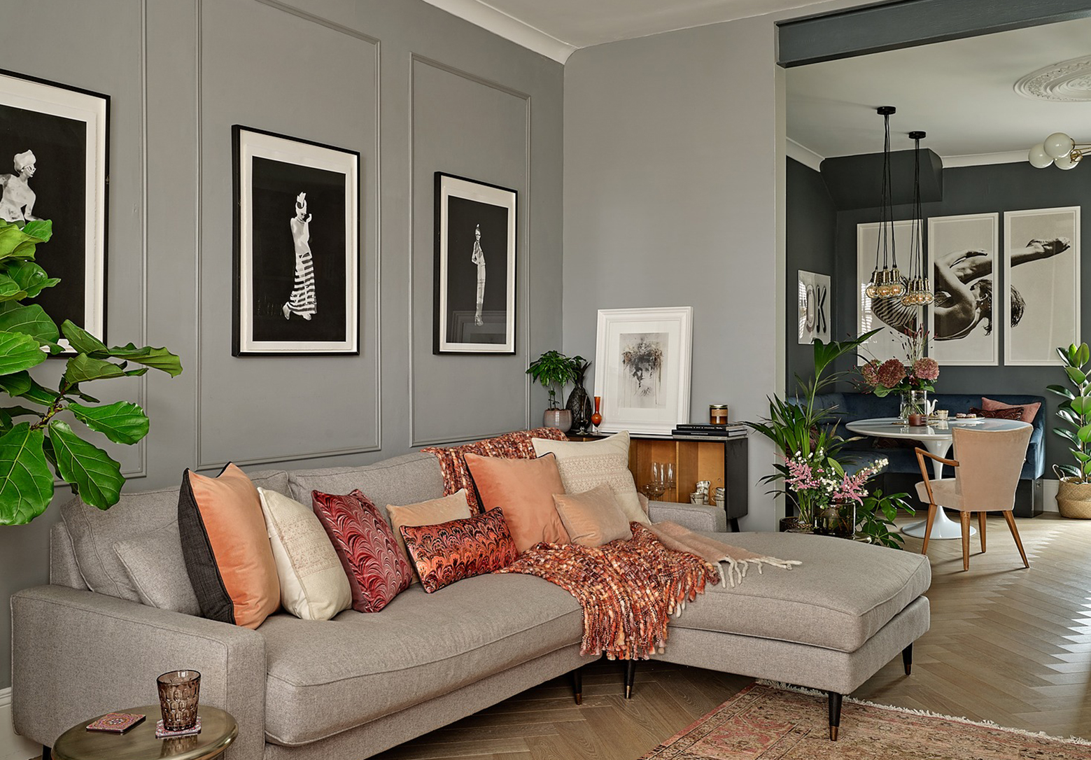 Living room with wood-panelling grey sofa, parquet flooring. Example of quiet luxury in interior design.