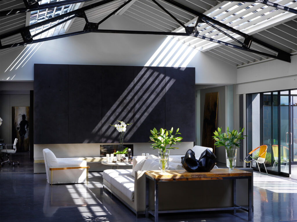 Warehouse conversion with high ceilings, beams and an industrial feel, contrasting black and white.